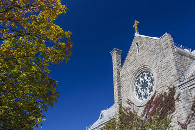 Low angle view of bell tower against clear blue sky