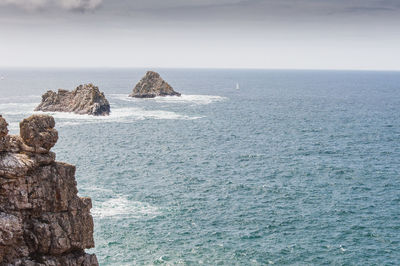 Rock formation in sea against sky