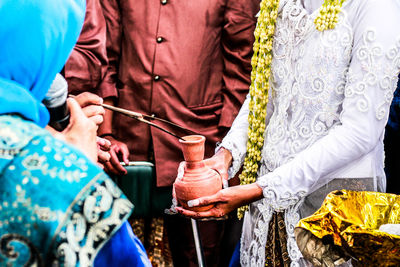 Midsection of bride and bridegroom during wedding ceremony