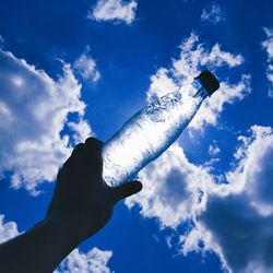 Low angle view of person hand against sky