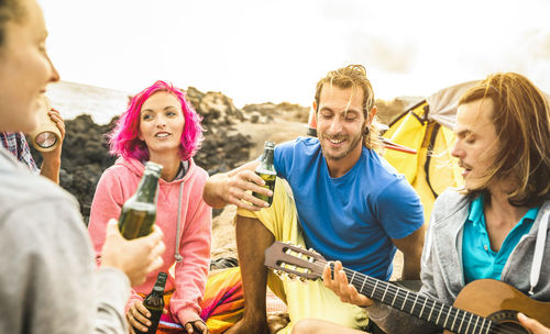 Male and female friends enjoying music at beach