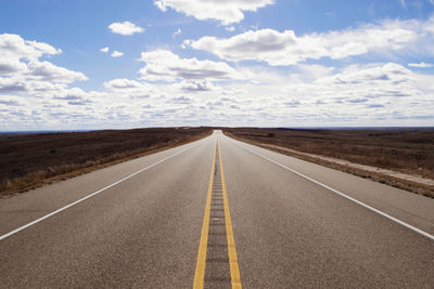 Empty road along countryside landscape