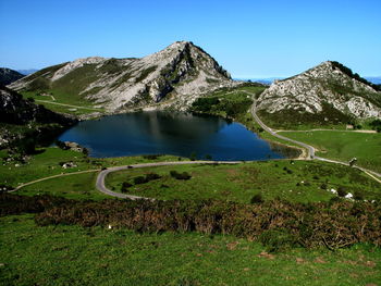Scenic view of lake and mountains against clear blue sky