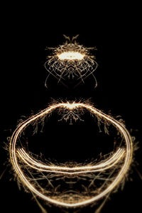 Close-up of illuminated lighting equipment against black background