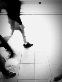 Low section of woman walking on tiled floor