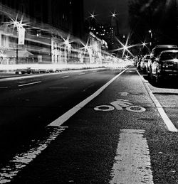 Road passing through illuminated city at night