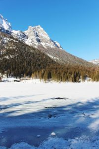 Scenic view of snowcapped mountains against blue sky