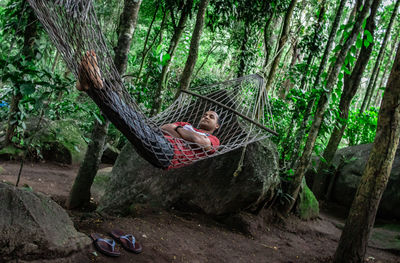 Woman sitting on tree trunk in forest