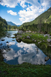 Scenic view of lake by mountains against sky