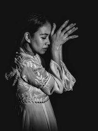 Side view of woman hand against black background