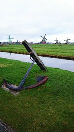 Water wheel in grass against sky