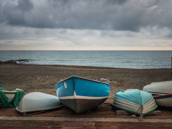 Deck chairs on beach against sky