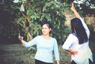 Friends standing against plants