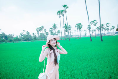 Full length of woman standing on field against sky