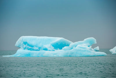 Ice floating on sea against sky