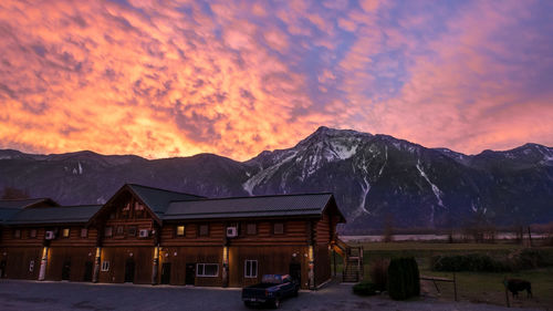 Built structure against mountains at sunset