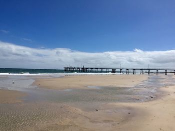 Scenic view of beach against blue sky