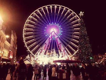 Low angle view of illuminated ferris wheel against sky at night