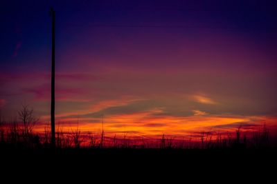 Silhouette landscape against dramatic sky during sunset