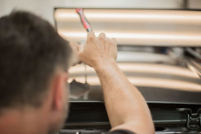 Close-up of man repairing car 