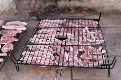 Grill full of raw meat ready for getting cooked in the barbecue. concept of lunch party outdoors.