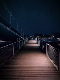 Empty footbridge against sky at night