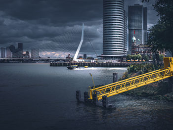 Bridge over river in city against sky