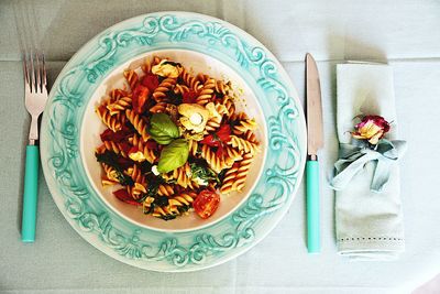 Directly above shot of pasta in plate amidst fork and table knife
