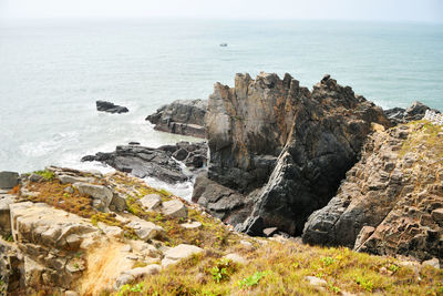 Photo of some weathered eroded cracked rocks on the coastline