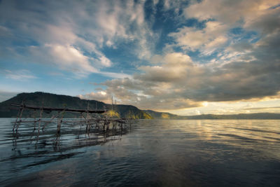 Mellow sunset over the mountains and lake, at lake toba, indonesia.