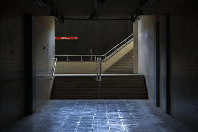 Under tunnel with stairs and sign that shows exit.