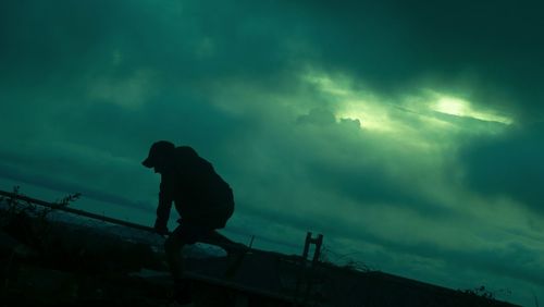 Low angle view of silhouette man against sky at night