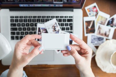 Midsection of man photographing with mobile phone on table