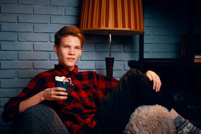 Portrait of boy sitting on sofa