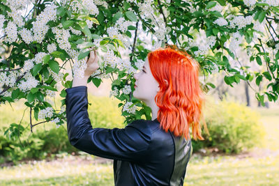 Rear view of woman standing against plants