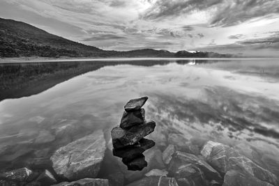 Scenic view of calm lake against cloudy sky