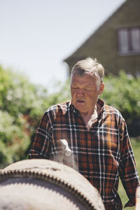 Senior man looking at cement mixer at yard