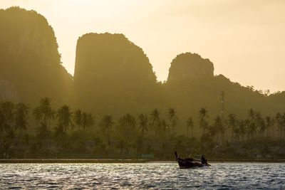 Silhouette of boat in lake during sunset