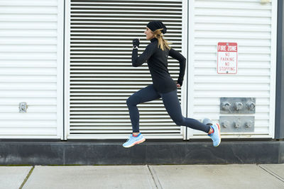 A woman running and jumping in the city.