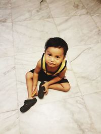 Portrait of cute boy sitting on floor