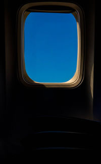 Clear blue sky through airplane window