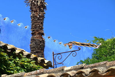 Low angle view of arrow sign against clear blue sky