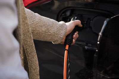 Man charging electric car at station