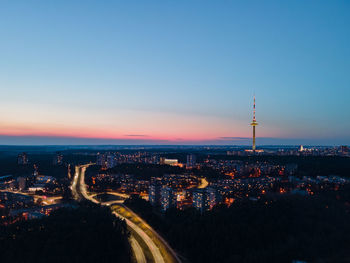 High angle view of city lit up at sunset