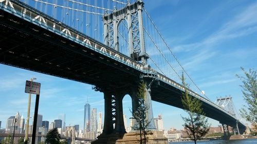 Low angle view of suspension bridge against sky