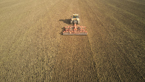 Drone aerial shots of a tractor ploughing a field at stone creek, sunk island, east yorkshire, uk.