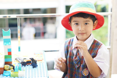 Portrait of cute boy holding hat