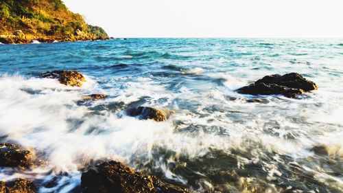 Scenic view of rocks in sea against sky