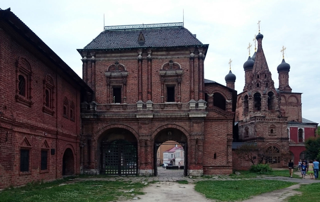 architecture, built structure, building exterior, arch, the way forward, facade, sky, day, history, outdoors, spire, footpath, town, tall - high, archway, old town, diminishing perspective, famous place, tourism