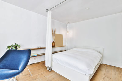 Empty chair on bed against wall at home